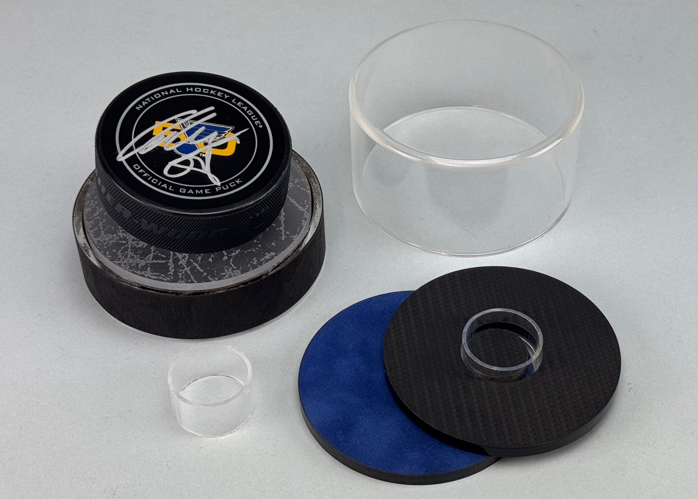 Signed Alex Pietrangelo St. Louis Blues NHL hockey puck on black woo veneer base and ice insert. Next to the base is a clear small dome as well as two insert pieces showcasing blue velvet and 